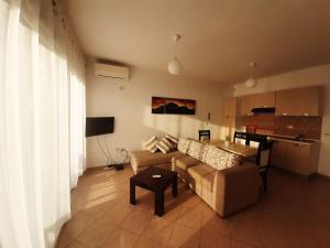 a living room with a couch and a table at Kela Apartments in Sarandë