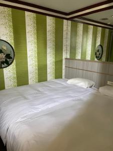 a bed in a room with green and white stripes at Mei Hua Hotel in Kaohsiung