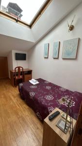 1 dormitorio con cama y mesa con mando a distancia en H. LAVID, en Briviesca