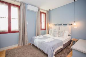 um quarto com uma cama e duas janelas em Liiiving in Porto - Historic Clérigos Apartments no Porto