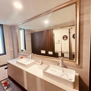 baño con 2 lavabos y espejo grande en 嵐文人旅店, en Chishang