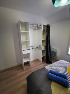 een slaapkamer met een bed en een boekenplank bij Le Puzzle in Trélazé