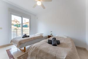 zwei Betten in einem weißen Zimmer mit Fenster in der Unterkunft Villa in Los Flamencos in Sitio de Calahonda + 23 Fotos