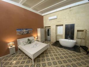 y baño grande con bañera, cama y bañera. en Ta' Tereza en Xagħra