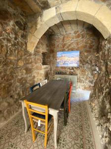 un comedor con una mesa de madera en una pared de piedra en Ta' Tereza en Xagħra