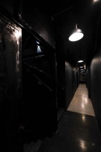 a dark room with a hallway with a light at Man Cave Hostel Vientiane in Ban Nongdouang