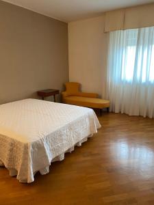 sypialnia z łóżkiem, krzesłem i oknem w obiekcie Appartamento con veranda Via Castel del Monte w mieście Andria