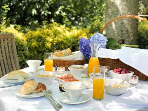 a table with breakfast foods and orange juice on it at Quinta Da Bouca D'Arques in Vila de Punhe
