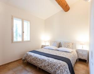 ein weißes Schlafzimmer mit einem Bett und einem Fenster in der Unterkunft Mas du Clos , Tilleul in Roussillon