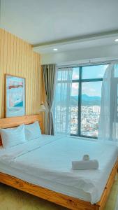 1 dormitorio con 1 cama grande y ventana grande en An's Oceanus House Nha Trang en Nha Trang