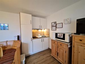 uma cozinha com um frigorífico branco e um micro-ondas em Montana Haus, Fewo B20 em Oberstdorf