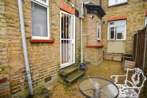 ein Backsteinhaus mit einer Bank und einem Fenster in der Unterkunft Lincoln Lodge, 2-bedroom,2-bathroom,ground floor flat in Southend-on-Sea