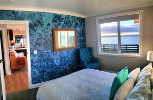 a bedroom with a bed and a window at Red Rock Cottage, beachfront luxury in Clarks Beach