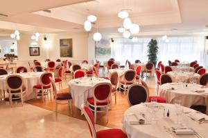 ein Restaurant mit weißen Tischen und roten Stühlen in der Unterkunft Residence Il Patio in Iseo