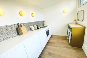 a kitchen with white cabinets and a counter top at Old Port - Terrace with exceptional view! in La Rochelle