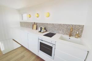 a white kitchen with a sink and a counter at Old Port - Terrace with exceptional view! in La Rochelle