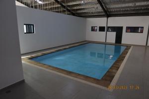 a large indoor swimming pool in a white room at Katonga Lolani Apartment in Lusaka