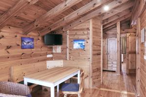 ein Esszimmer in einem Blockhaus mit einer Holzwand in der Unterkunft MOUNTAINRANGER - Lodge in Obertauern