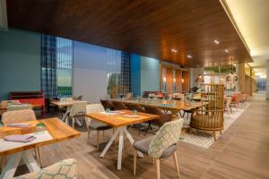 um restaurante com mesas e cadeiras de madeira e janelas em Hyatt Centric San Salvador em San Salvador
