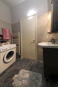 a bathroom with a washing machine and a sink at Stay Here - Διαμέρισμα στο κέντρο του Βόλου in Volos