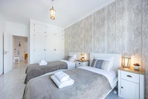 - 2 lits dans une chambre avec des murs blancs et des lumières dans l'établissement Stylish Seashore Apartment, à Lagos