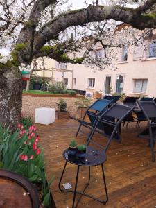 Charentay的住宿－La Maison des Vignes，庭院里设有桌子和一棵树,种有鲜花