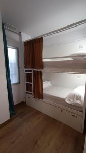 アリカンテにあるVAD HOSTEL ALICANTEの二段ベッド2台と窓が備わる客室です。