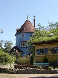 una casa grande con techo de hierba y un edificio en Villa Vilu, en Naantali