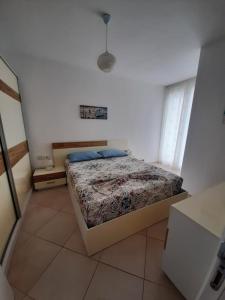 a bedroom with a bed in a white room at Kela Apartment 3 in Sarandë