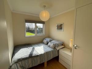 a small bedroom with a bed and a window at 170 Broadside Holiday Chalet near Broads & Beaches in Stalham