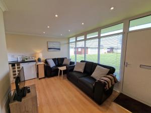 a living room with a couch and a table at 170 Broadside Holiday Chalet near Broads & Beaches in Stalham