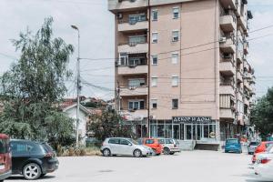 a parking lot with cars parked in front of a building at ASPERA Apartments in Kumanovo