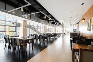 a dining room with tables and chairs and windows at Staz Hotel Ulsan in Ulsan