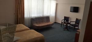 فندق ديليجان ريزورت في ديليجان: غرفة في الفندق مع أريكة وكرسي