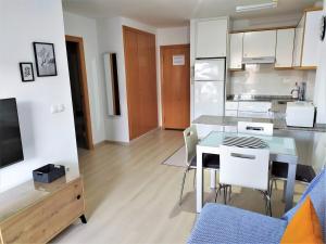 eine Küche und ein Wohnzimmer mit einem Tisch und einer Theke in der Unterkunft El Racó in Canet d'en Berenguer