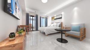 een slaapkamer met een bed, een tafel en een stoel bij Foshan Laide Apartment in Shunde