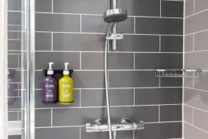 a shower with two bottles on a shelf in a bathroom at Holiday Inn Express Southwark by IHG in London