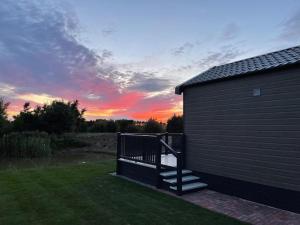 a building with a staircase next to a sunset at Chapel Fields Holiday Park in Chapel Saint Leonards