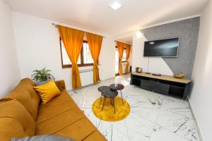 a living room with a couch and a table at Hedonist Spa Apartment in Sarajevo