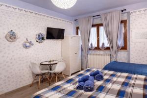 een slaapkamer met een blauw bed en een tafel en stoelen bij Locanda del sorriso b&b in San Quirico dʼOrcia