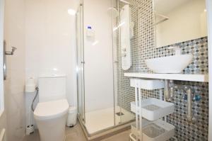 a bathroom with a shower and a toilet and a sink at Apartamentos ALAZUL JRJ in Conil de la Frontera +55 photos