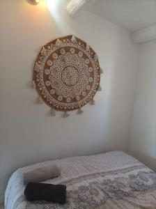 1 cama en un dormitorio con un plato en la pared en n°9. gite 5 Personnes, en Saint-Aubin-de-Nabirat