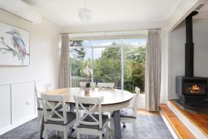 a dining room with a table and a fireplace at Camellia Cottage in Wentworth Falls