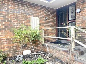 a brick house with a front porch with a white door at Penlink Lodge - Base To Explore Mornington Peninsula in Langwarrin