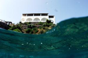 a house with a surfboard in the water at Hotel Cincotta in Panarea