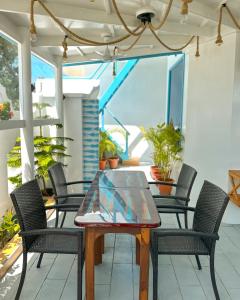 a patio with a glass table and chairs at Rushkokaa Beach Villa in Fulidhoo