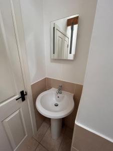 a bathroom with a white sink and a mirror at The Old Stables in Mews in Kessingland
