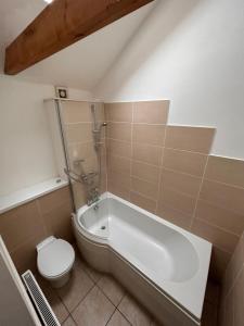 a bathroom with a toilet and a tub and a sink at The Old Stables in Mews in Kessingland +12 photos