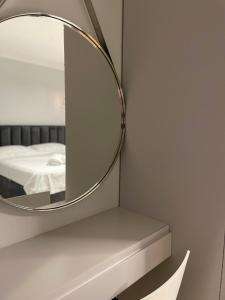 a mirror on a wall next to a bed at Honey Suite in Tirana