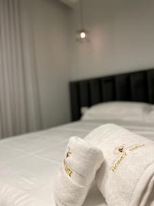 un par de toallas sentadas encima de una cama en Honey Suite, en Tirana